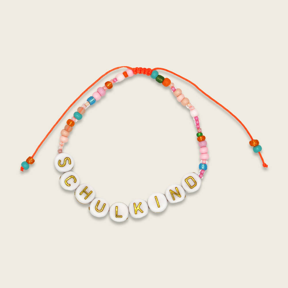 Perlenarmband Schulkind in orange/rosa und goldenen Buchstaben mit Säckchen in hellblau/weiss